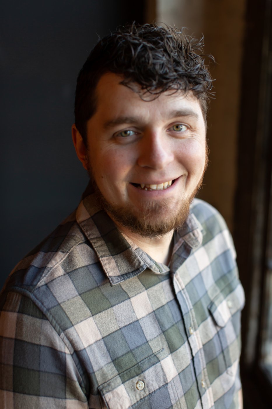 Josh Reed smiling beside a window